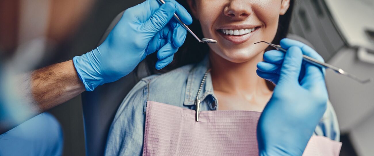 Dental professional examining patient's teeth and gums, preventing gum disease in Boulder, CO